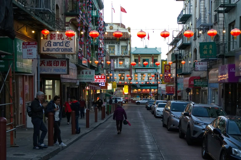 several people on the sidewalk near a bunch of buildings