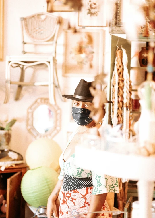 a woman with a face mask standing in front of various objects