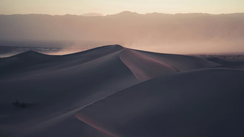 sand dunes in desert with mist at dusk