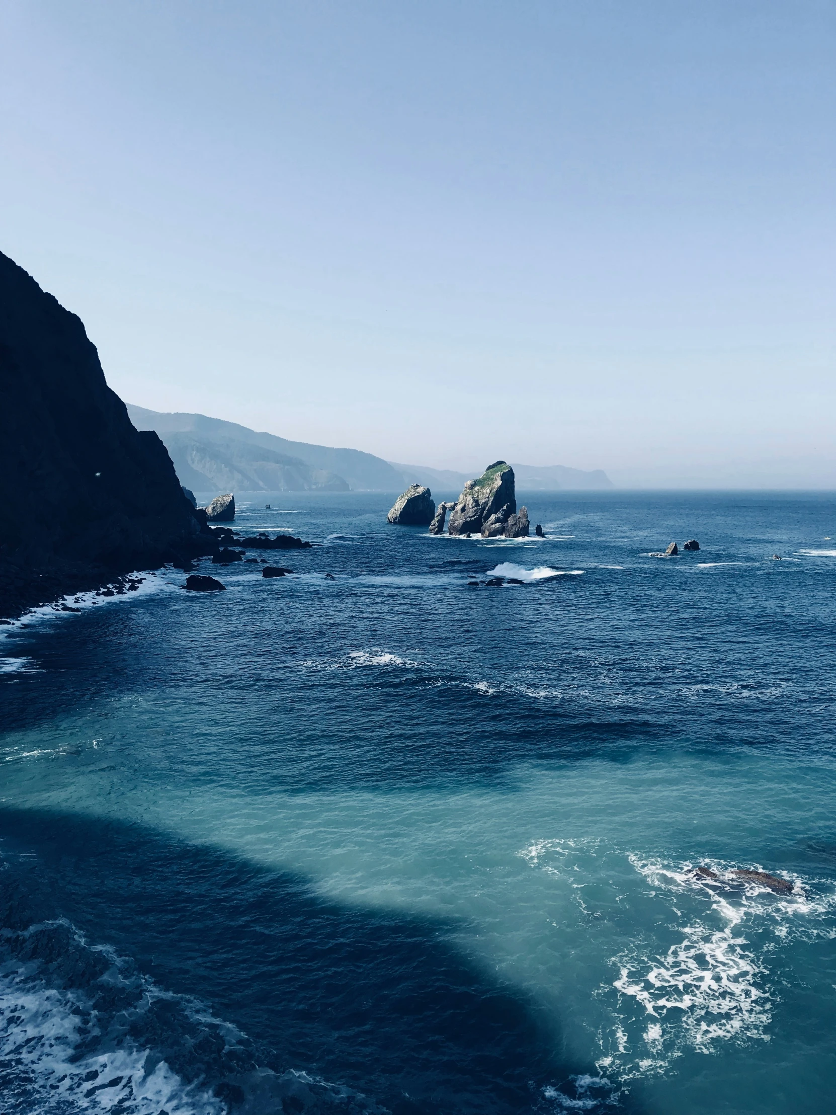 the view of an island and some blue ocean