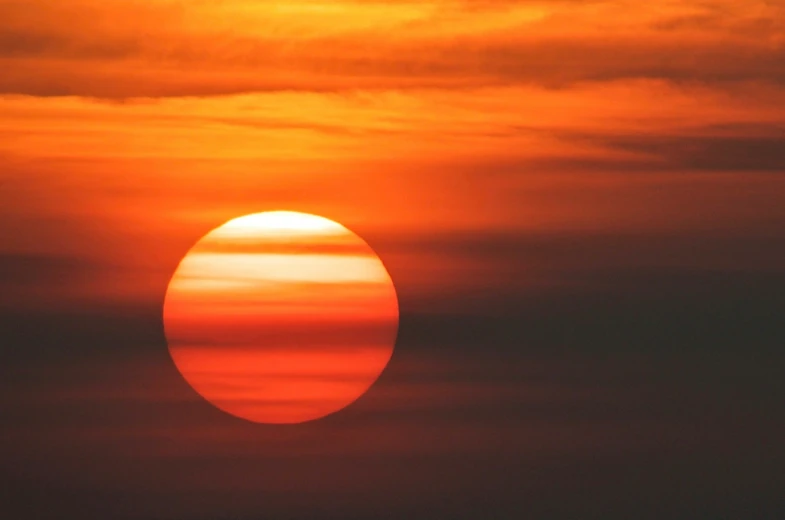 the sun is setting behind some dark clouds