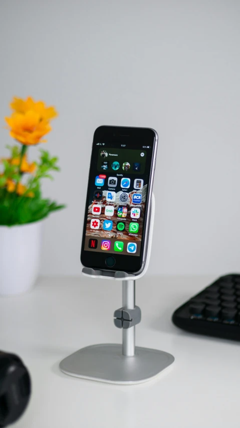 an iphone is hooked up to an air vent on a desk