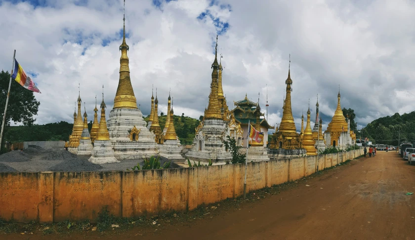 several golden spires on the roof of two buildings