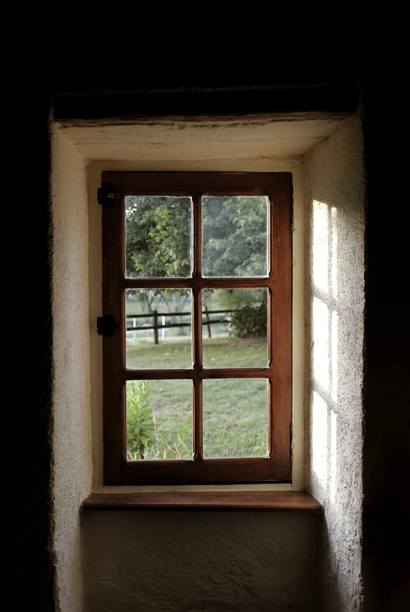 the open window shows the view of the pasture outside