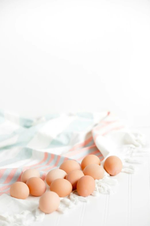 a group of eggs in a basket sitting on top of a towel