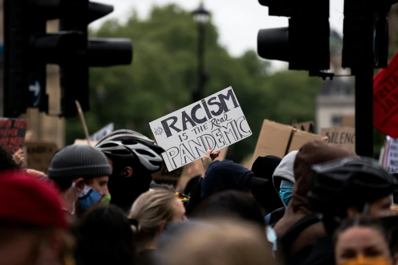 a crowd of people are holding protest signs