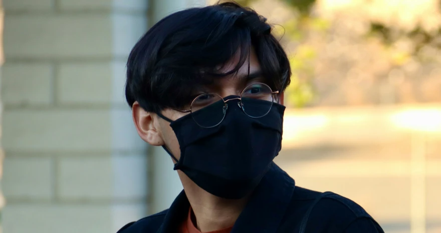 the man is wearing a black mask to shield his face