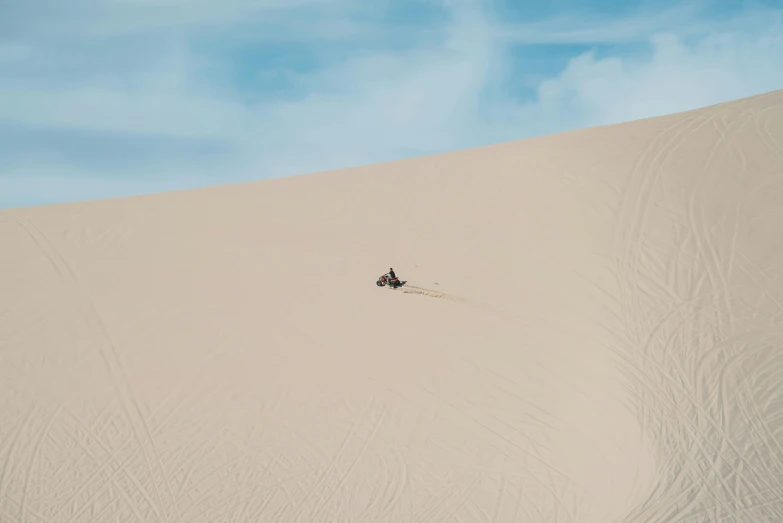 two people riding motorcycles on top of a large desert