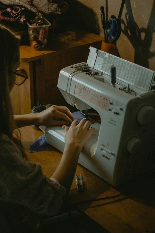 a woman is sewing on a sewing machine