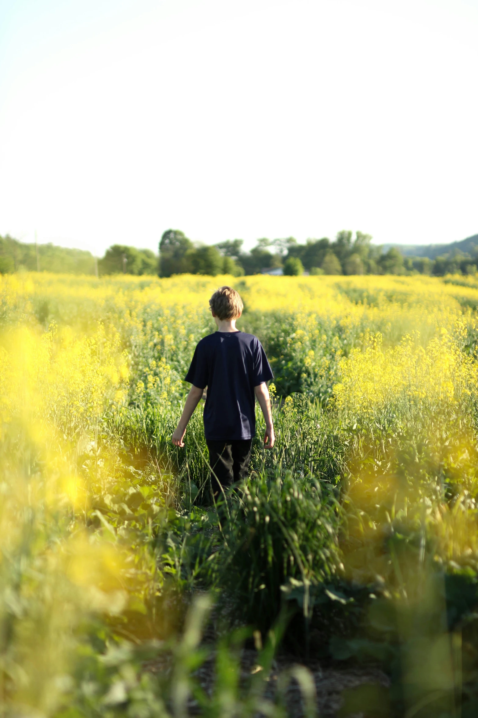 a young person walking through the middle of a field