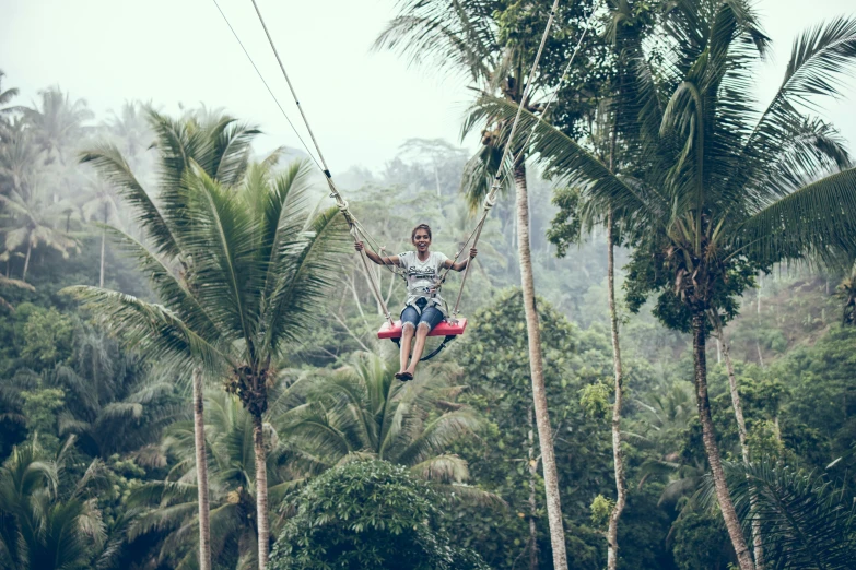 a woman hanging from a rope high up in the air