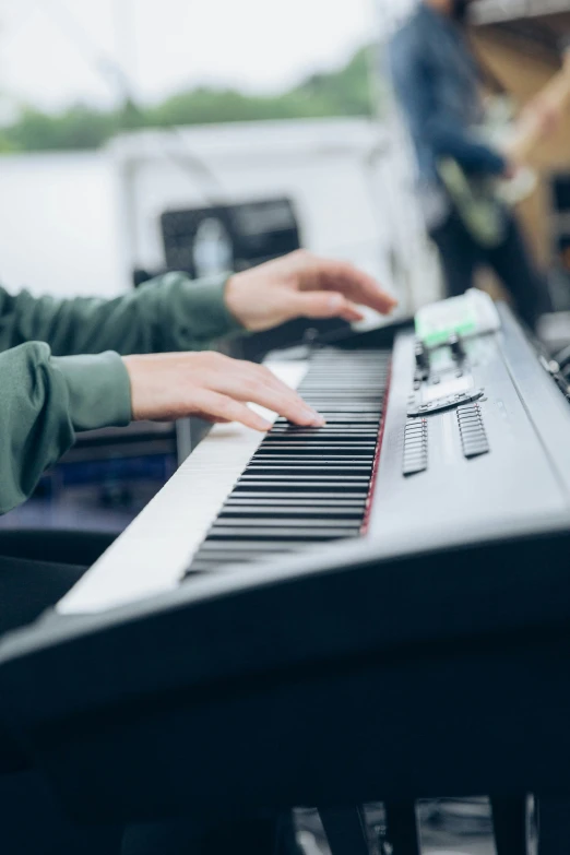 a person that is playing the keyboard in front of some people