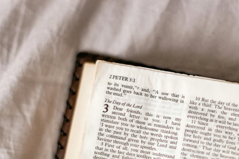 an old book is sitting on a bed