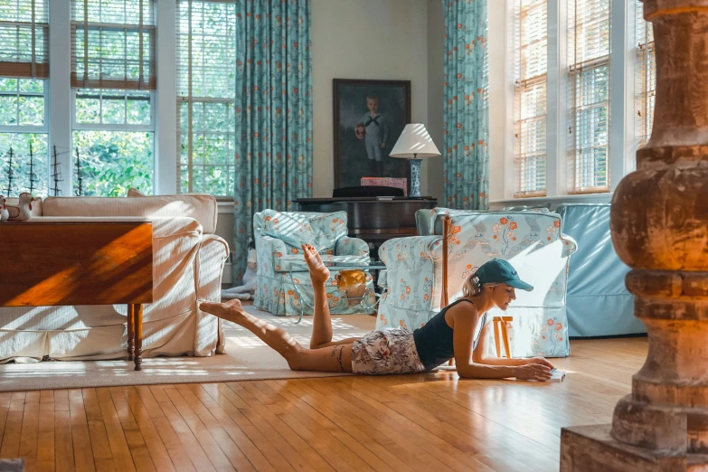 a young woman sitting on a floor in front of windows