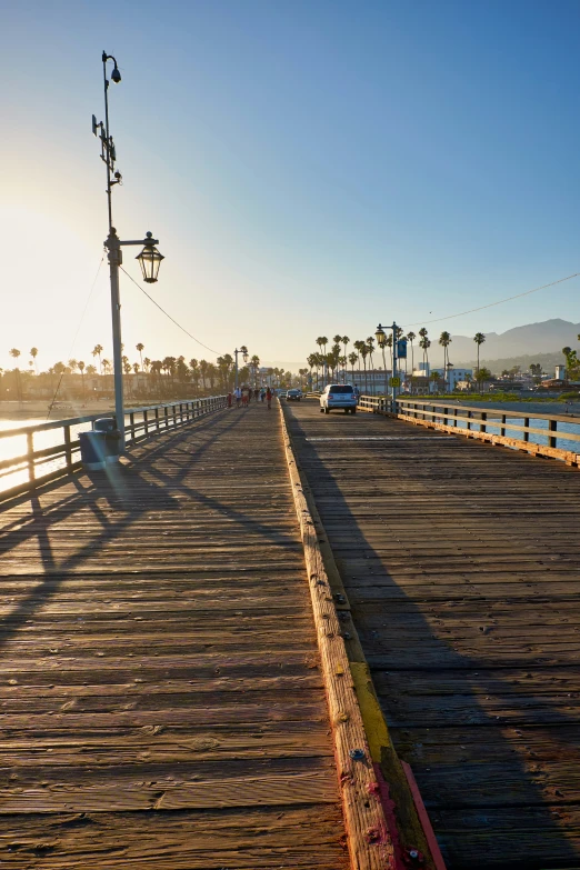 an empty pier with boats, people and palm trees