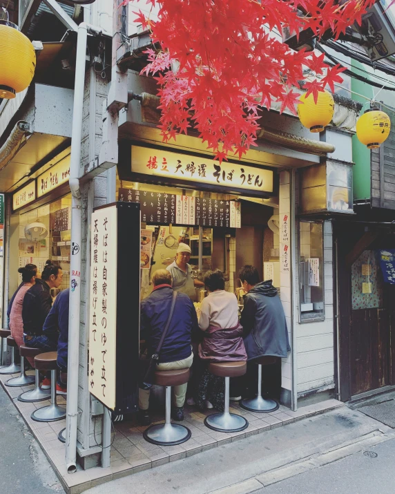 people are gathered in front of a restaurant