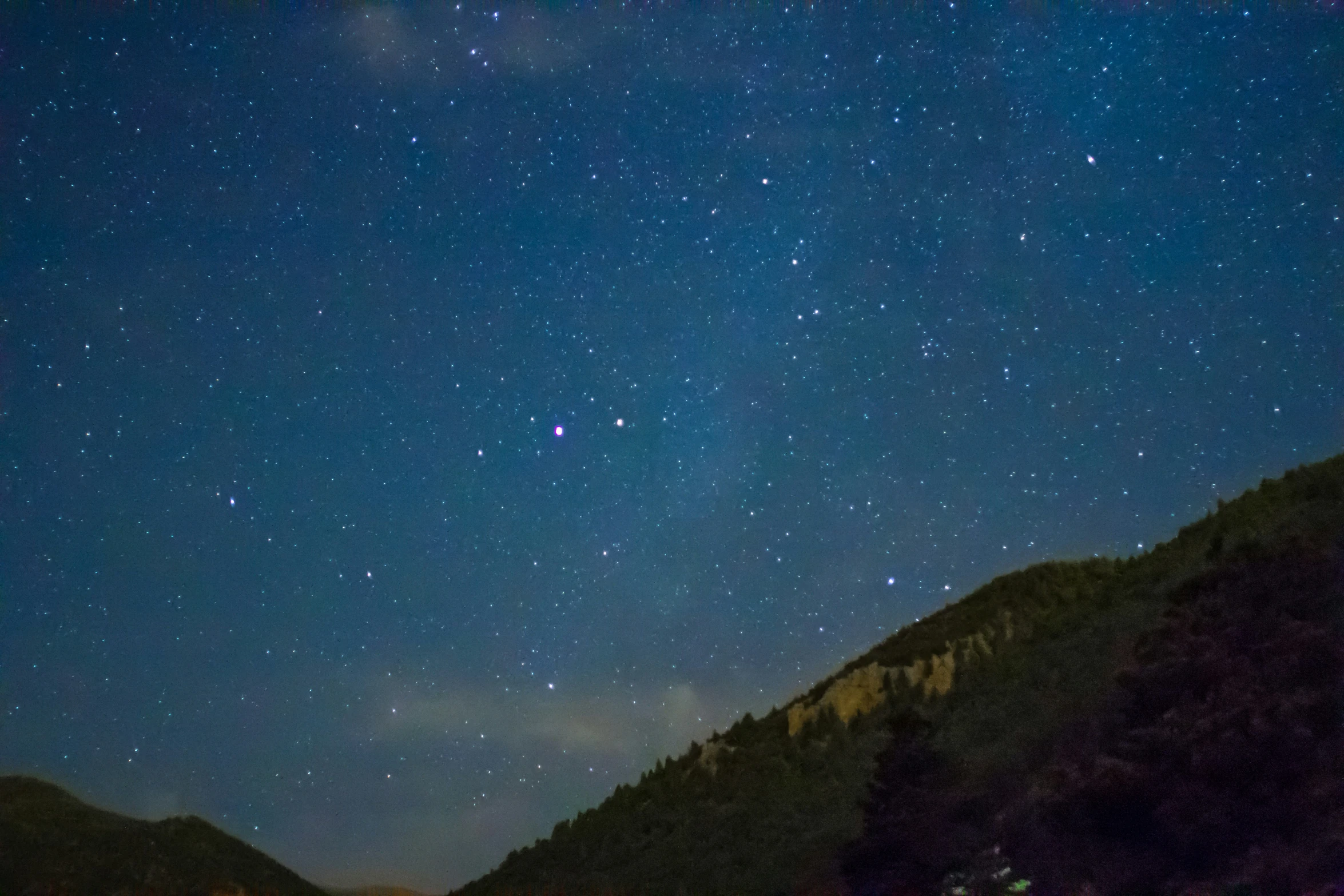 the sky filled with lots of stars over mountains