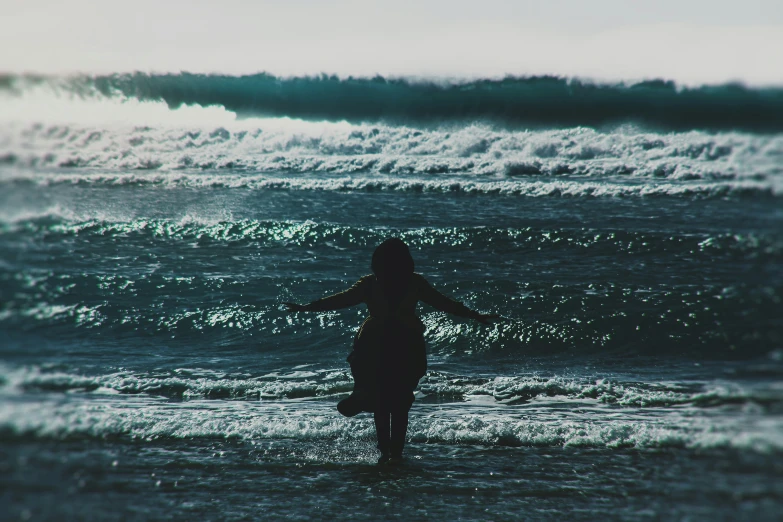 a woman is wading through the water with her surfboard