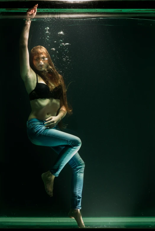 the woman in jeans is wearing a  top and posing underneath water