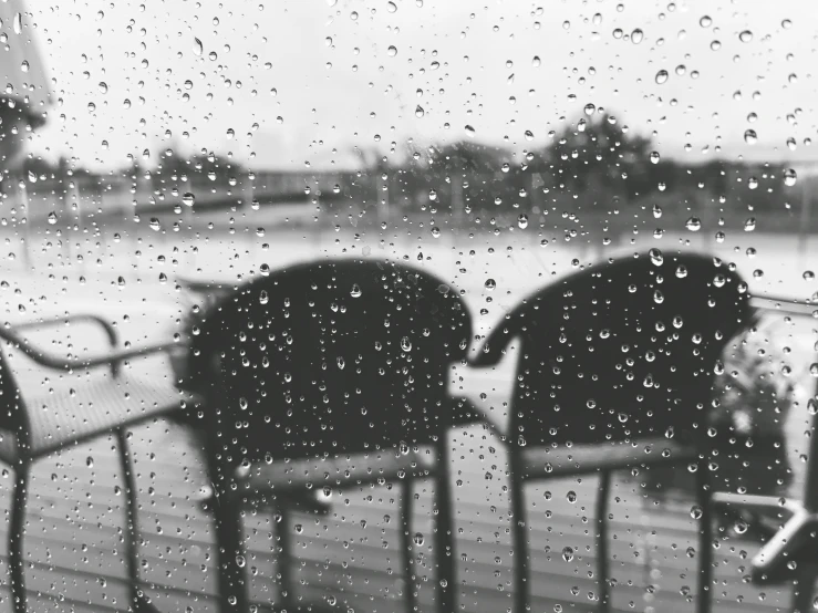 four chairs sit in front of a window as it is rainy