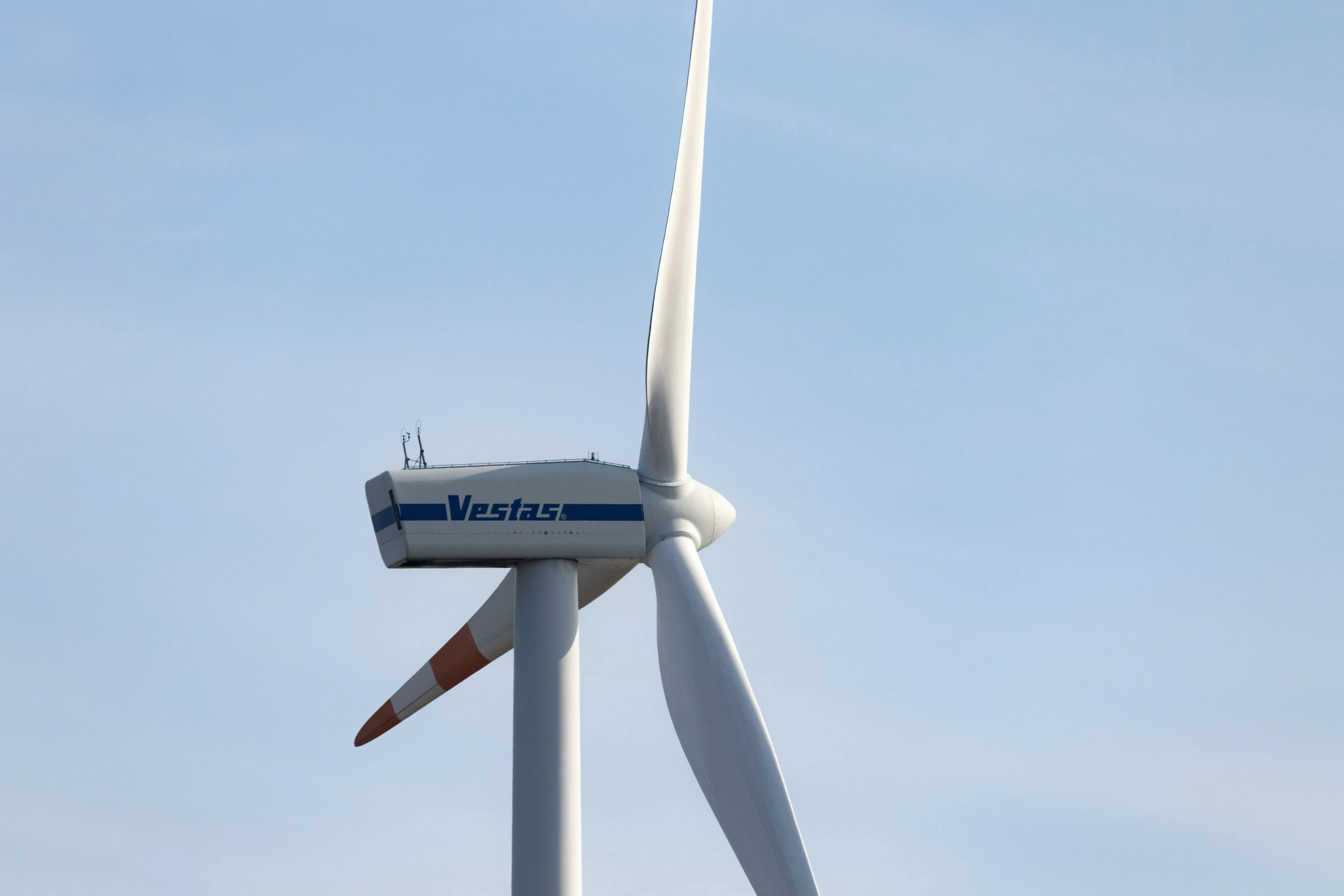 a white wind turbine with a white top and blue accents on the side