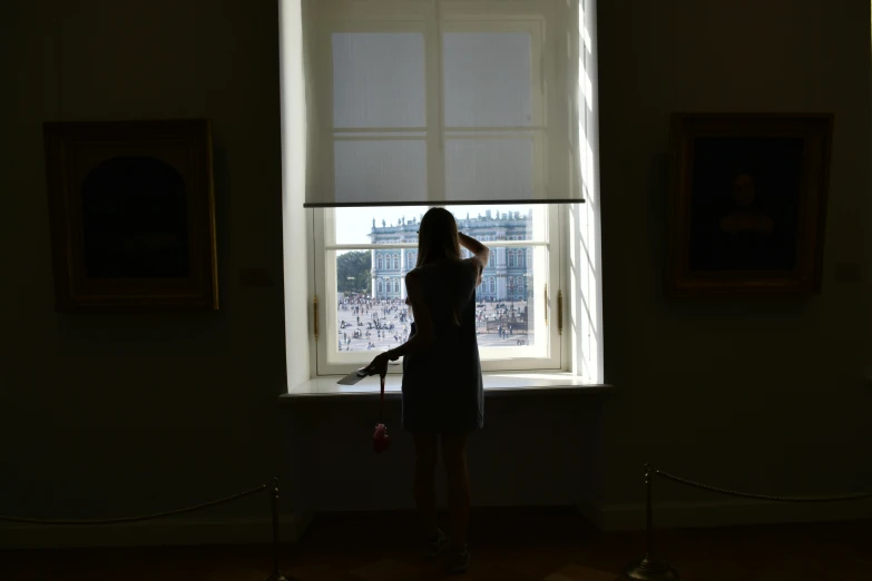 a woman with an object standing in front of a window