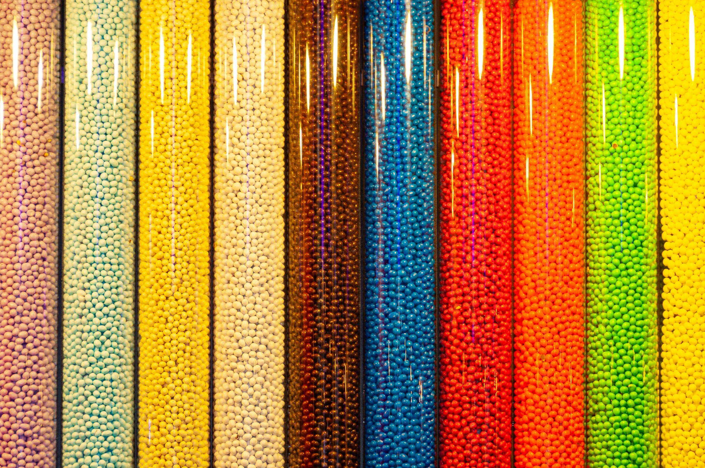 colorful beads are sitting on a display shelf in a store