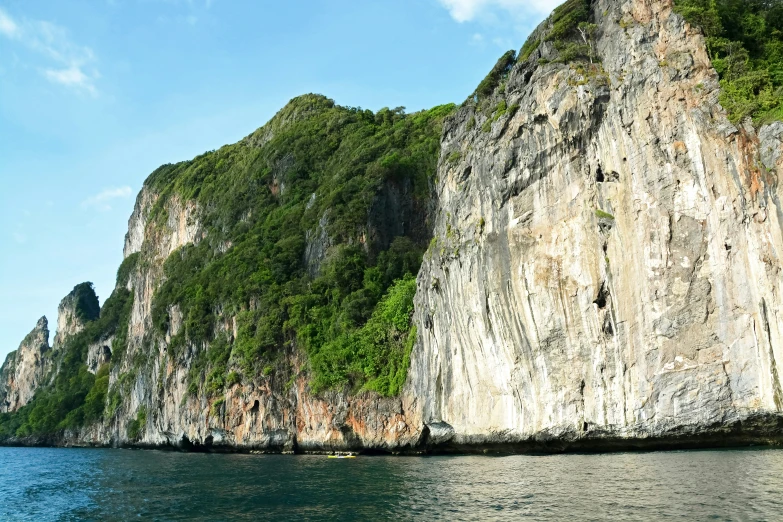 some very tall mountains near water with people