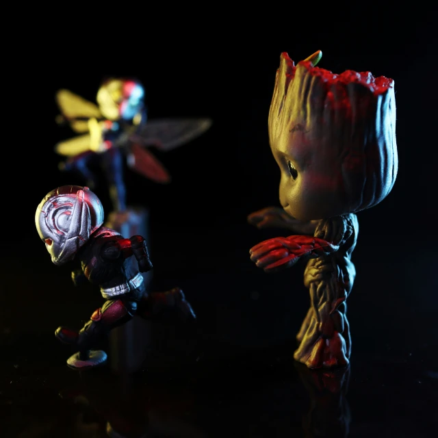 three dolls of different character in action on a dark surface