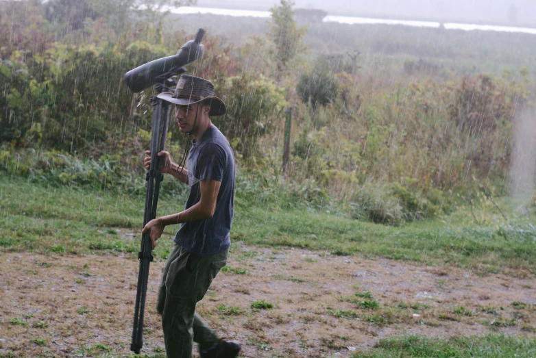 a man carrying a baseball bat in the rain