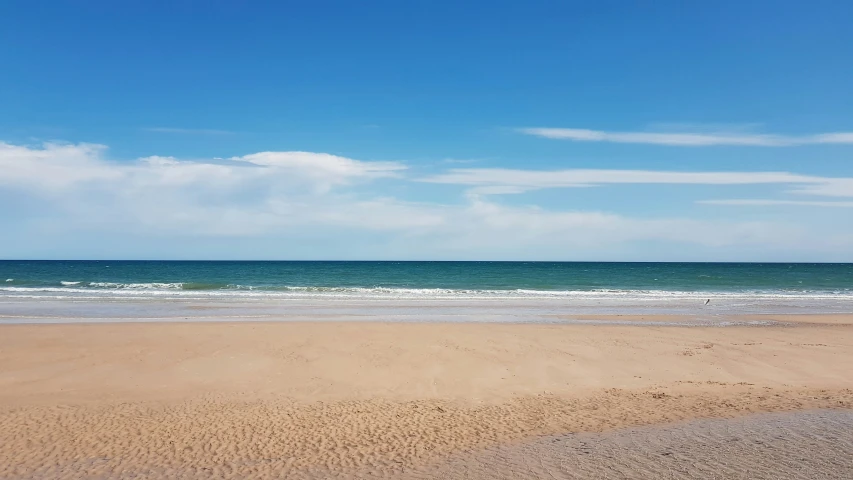 the ocean waves hit the beach on a sunny day