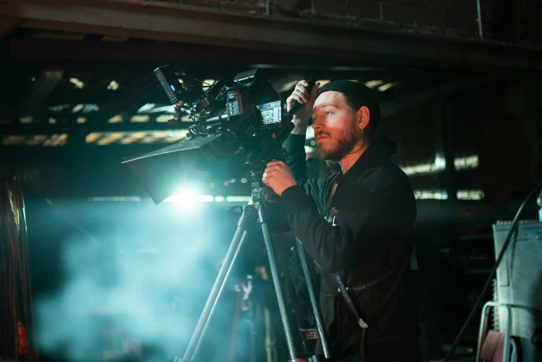 a man stands behind a microphone in front of a camera