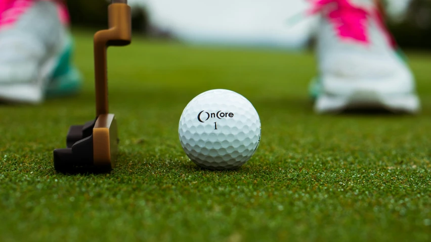 a closeup of a golf ball next to the tee