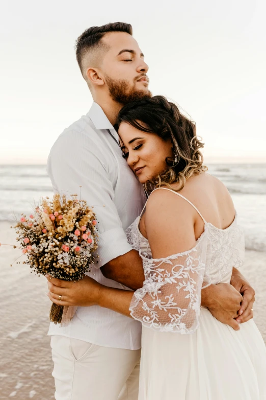 a couple posing for a picture while on the beach