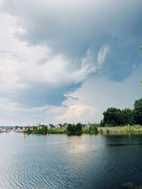 two boats floating down a river under clouds