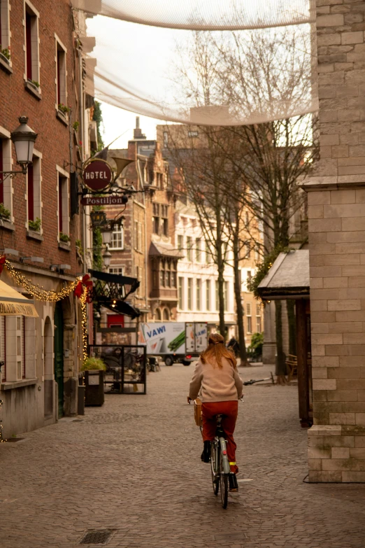 woman on bike wearing red pants in middle of street