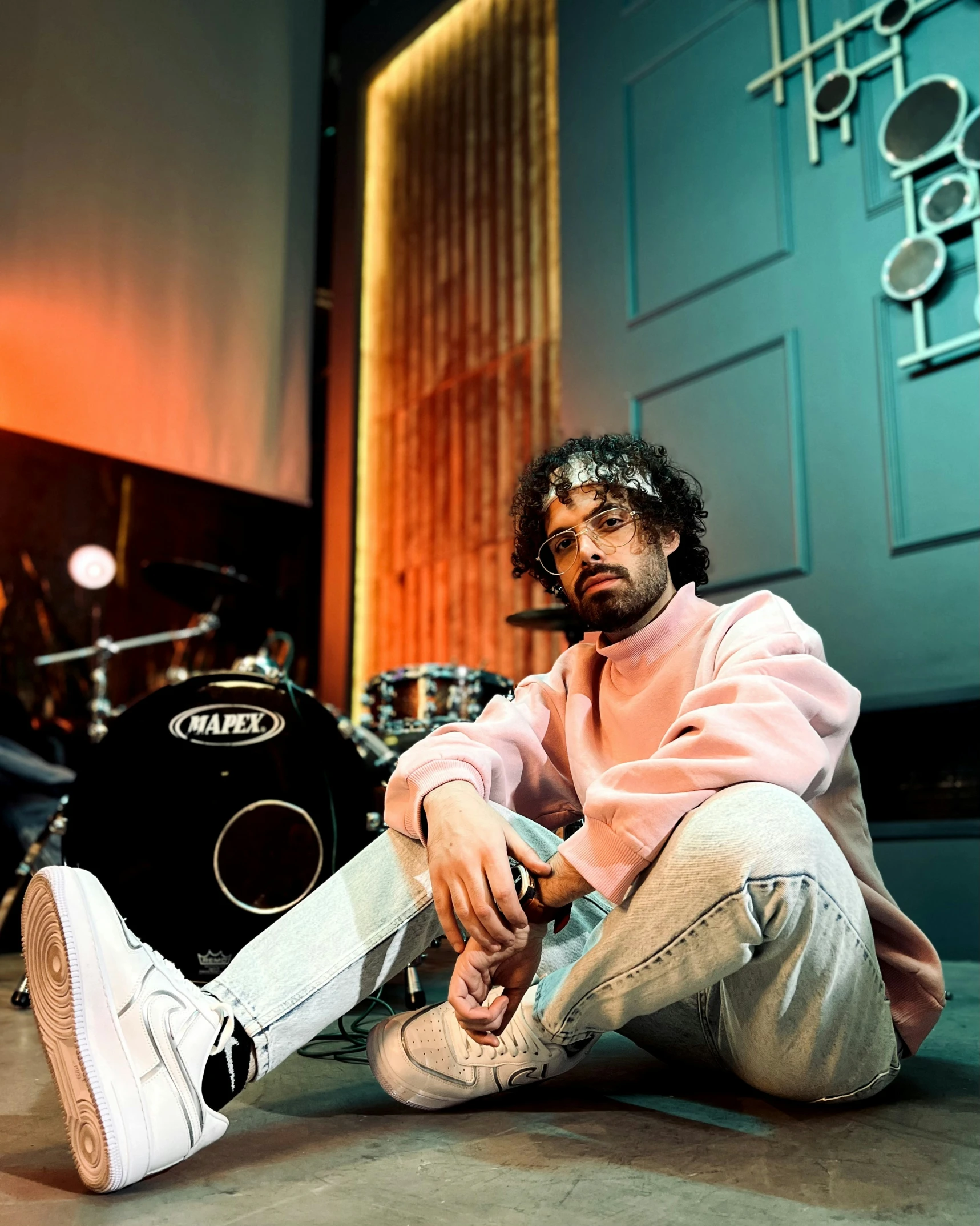 a man sits on the ground next to his guitar