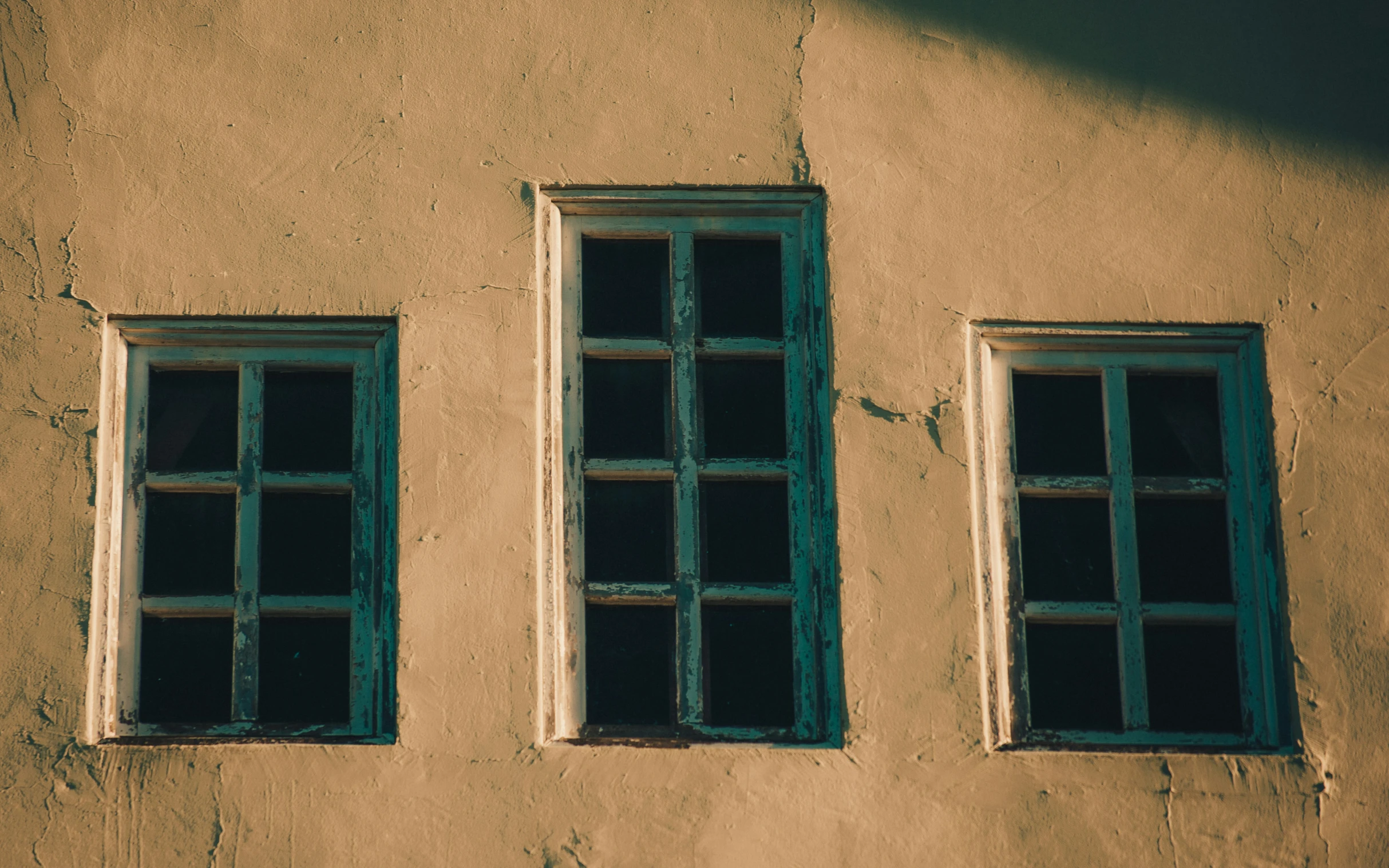 two windows on a wall in front of a building