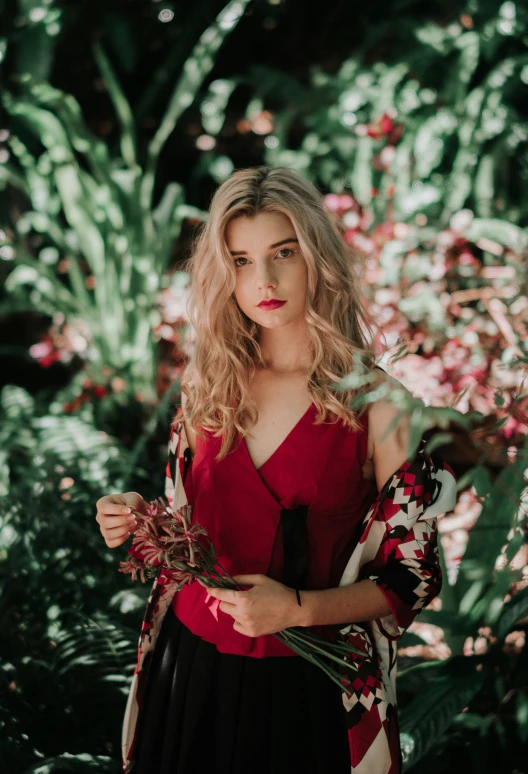 girl standing outside in a green garden with flowers and foliage