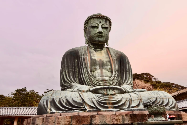 a statue of buddha is sitting outside in the sun