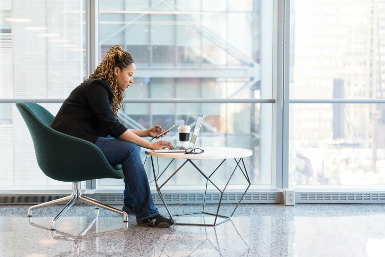 a woman sitting at a table using her laptop