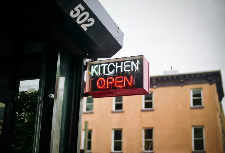 this is a sign that has the name kitchen open written on it