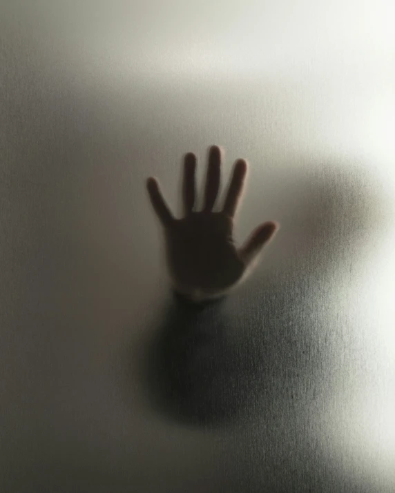 the shadow of a hand on a white wall