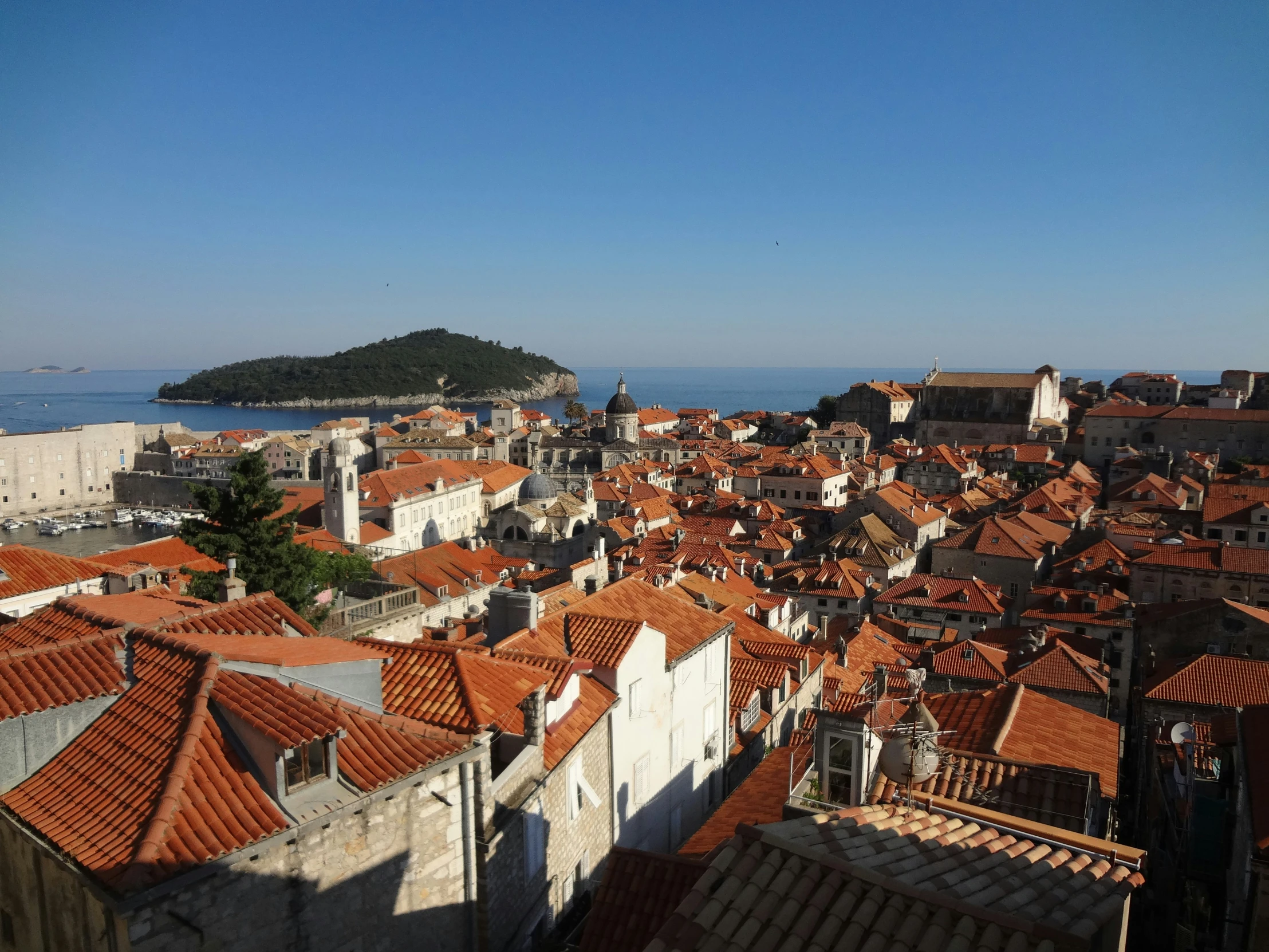 the roofs of many old houses overlooks a body of water