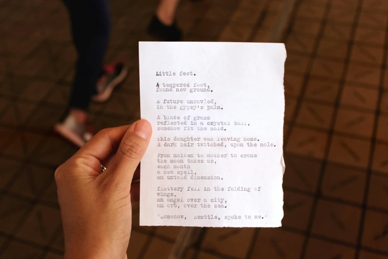 a piece of paper in someones hand with some writing on it