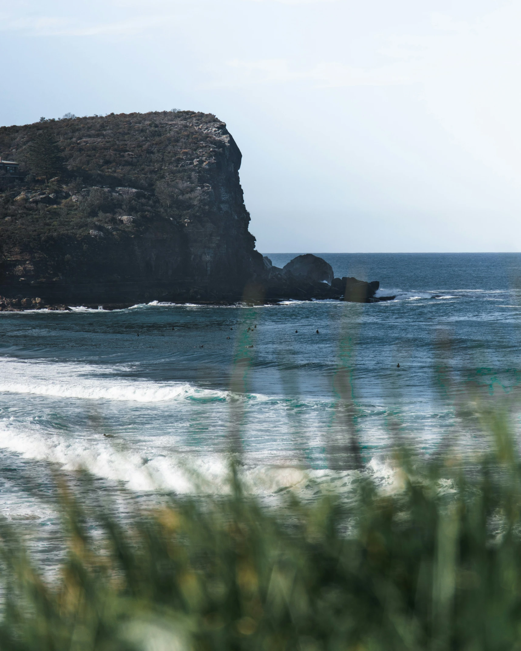 a man surfing on the water next to a cliff