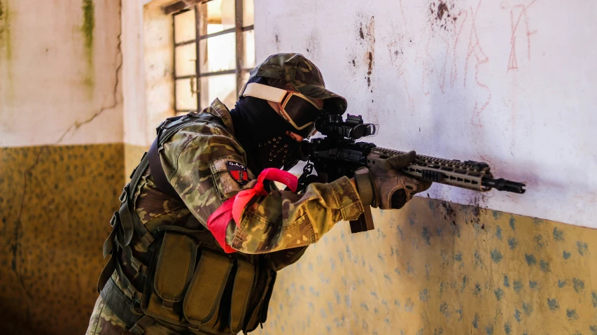 a person with a paintball gun looking through the window