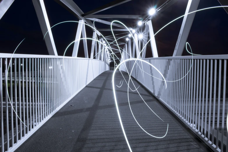 white metal walkway with bright white lights at night