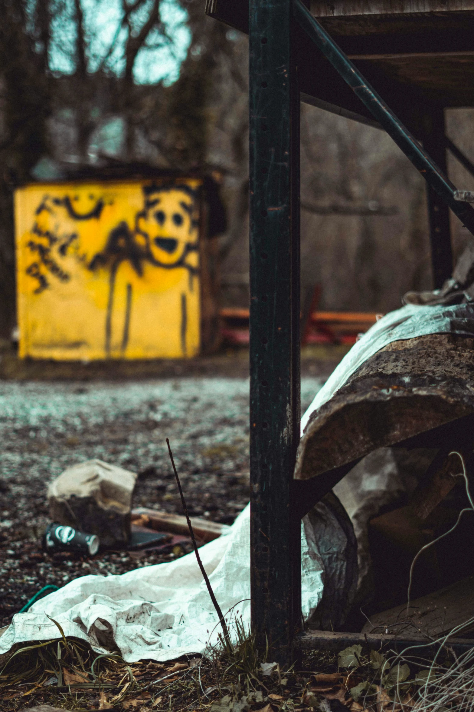 a trash covered area with graffiti on the wall