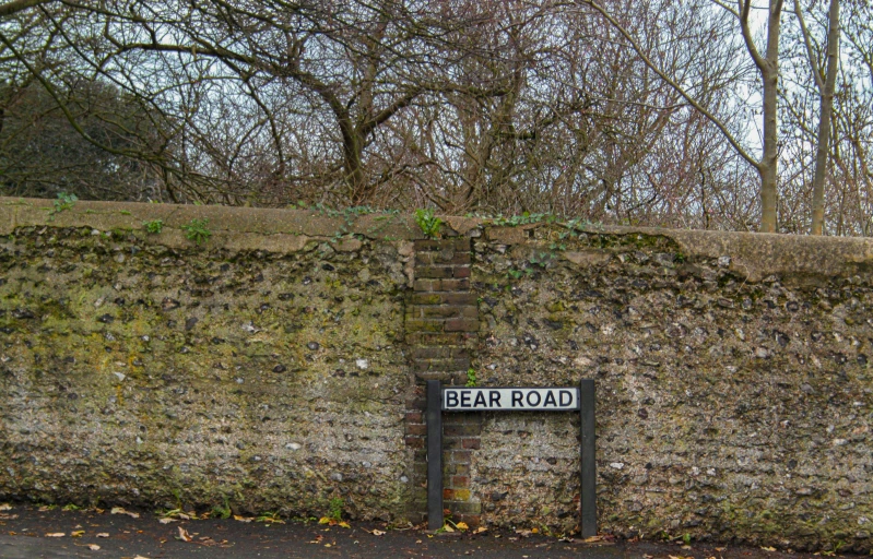 a sign in front of a stone wall that says bear road